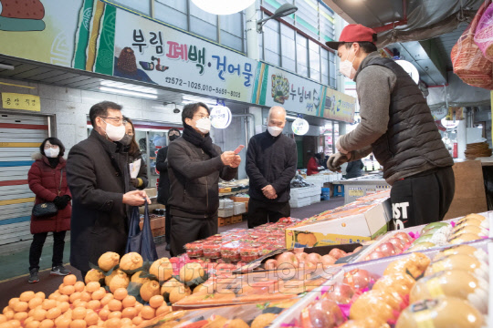 이재현 인천 서구청장(왼쪽 두번째)이 지난 2월 설을 맞아 관내 강남시장을 방문해 과일가게에서 '서로e음' 카드로 장을 보고 있다. <인천 서구청 제공>